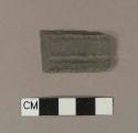 Flat gray slate fragment with one very smooth side and carved groove