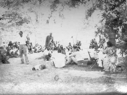 Large group of people sitting in the expedition camp, including Mm. Simões (right)