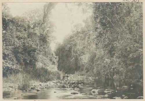 Two men standing on bank of river near Iligan, Misamis