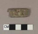 Rectangular lead fragment with raised letters on one side "...NTE"