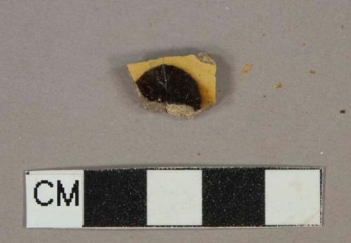 Yellow and brown slip-decorated earthenware vessel body fragment, buff paste