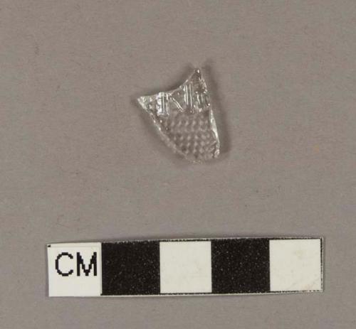 Colorless bottle glass fragment molded with a series of dots and embossed with "...N..."