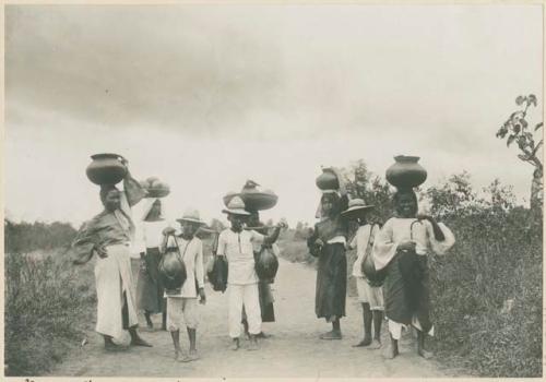 Women and girls bringing pots into Manila to sell