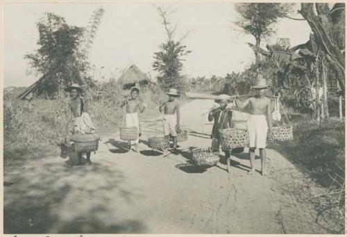 Man and boys transporting produce to Manila, pingas