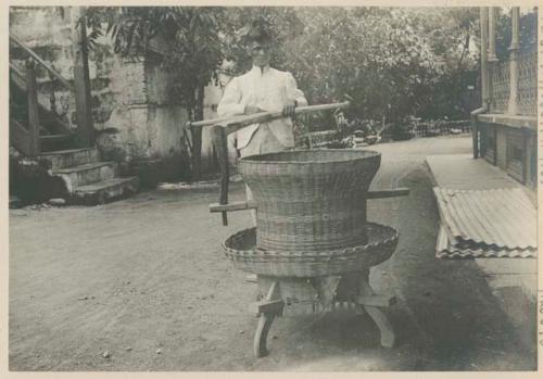 Man with Filipino machine for hulling rice