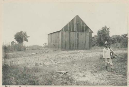 Man standing in front of machine shed, Government Rice Farm