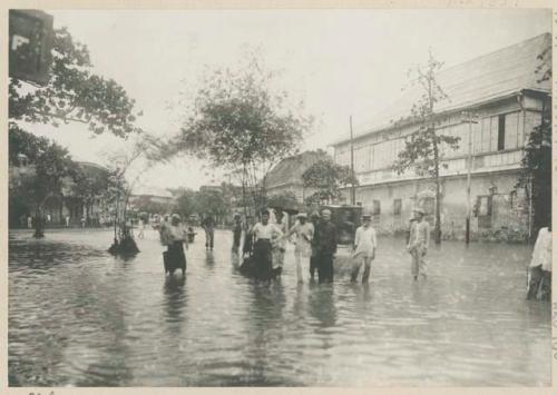 People standing in flooded street in Manila after typhoon