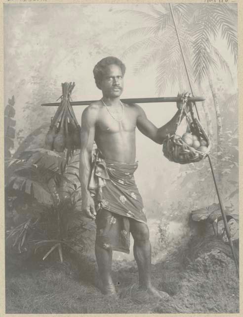 Studio staged portrait of man with carrying pole