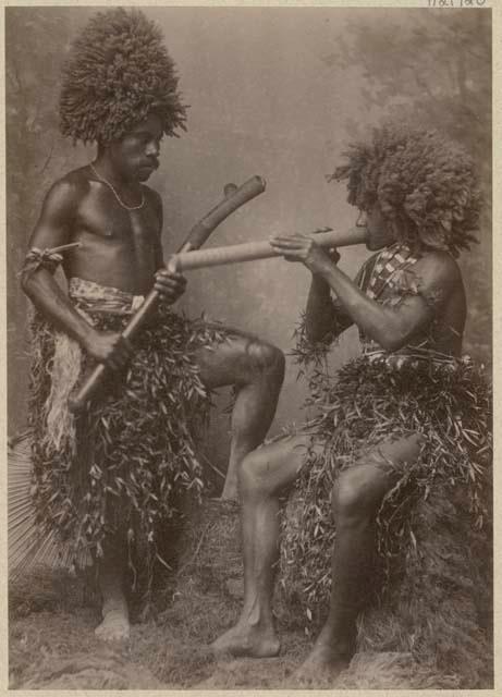 Studio staged portrait of two men holding weapons or instruments