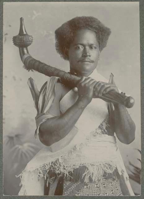 Studio staged portrait of man with club