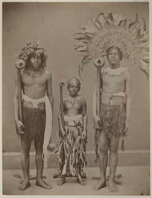 Three men standing in a row holding clubs