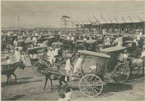 General view of vehicles and crowd in front of grand stand