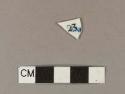 Blue hand painted whiteware body sherd; one side has text in blue "ENG" with black "23" stamped on top