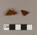 Brown glazed, buff bodied earthenware body sherds; two sherds crossmend