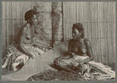 Two women with woven mat