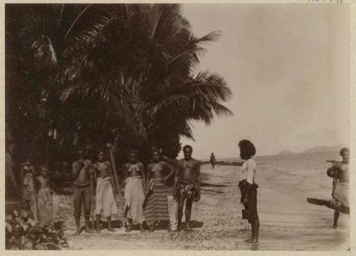 People on beach in front of jungle