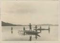 Men in canoe with fishing spears