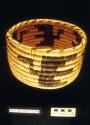 Coiled bowl-shaped basket with straight sides and flying bird motif