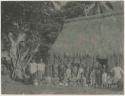 Group of people in front of thatched structure