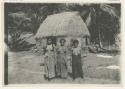 Three women standing outside a structure