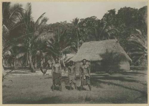 Three men standing outside a structure