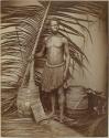 Studio portrait of a New Guinea man with items from various other cultures