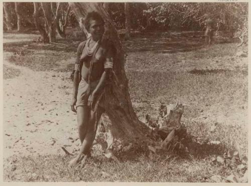 Woman leaning against a tree
