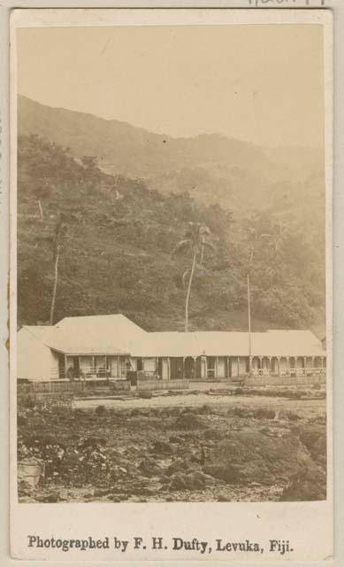 Long structure in front of hills and trees