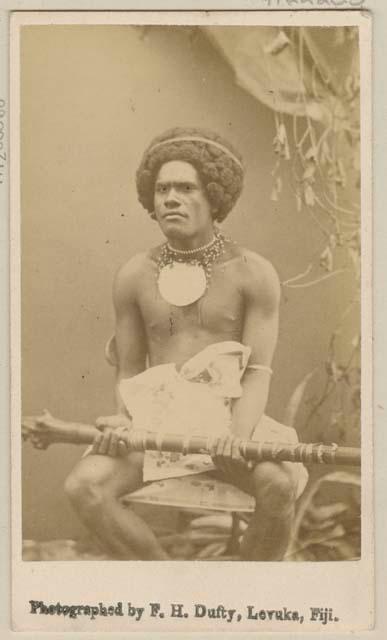 Posed studio portrait of man with club