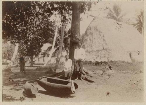 Two people in front of tree and thatched structure, [Macuata?]