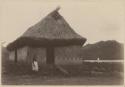Man standing in front of thatched church
