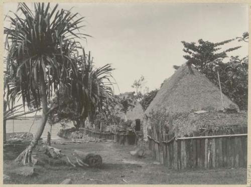 Two thatched structures next to shore