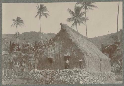 Two people in front of a house