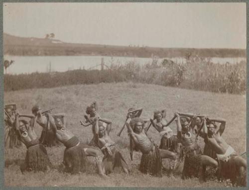 Group of meke dancers outside, holding clubs