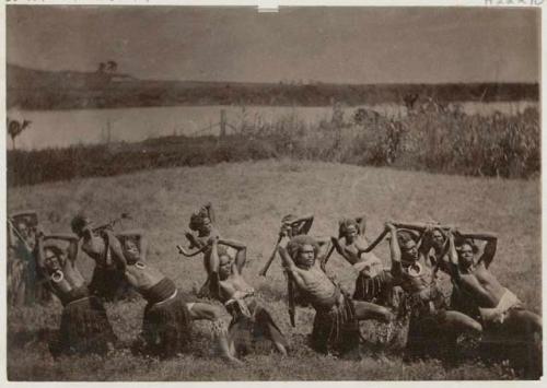 Group of meke dancers outside, holding clubs