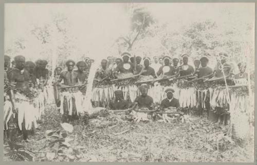 Group of male dancers outside, with clubs