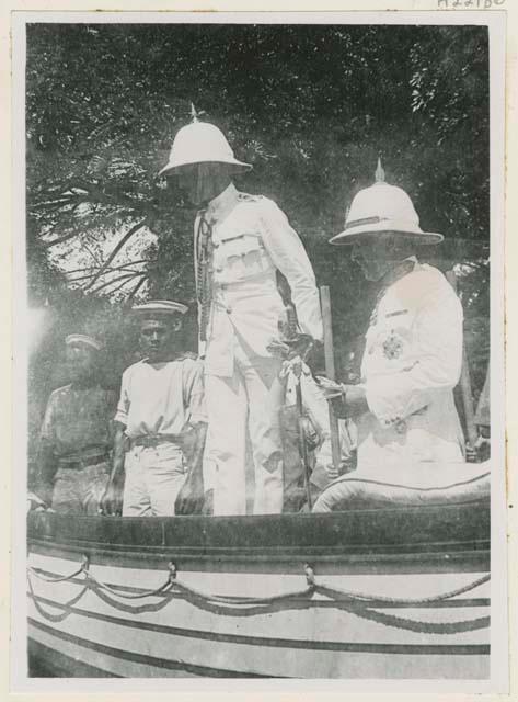 Governor in uniform arriving with other men in boat