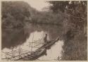 Two canoes, one with man sitting on it, Tamavua River