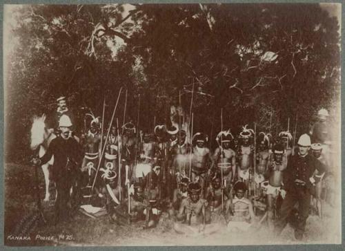 Group of people outside with weapons, including a few Western men