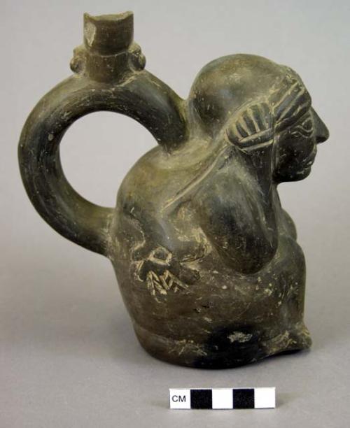 Stirrup spout- seated human figure