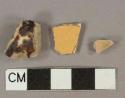 Yellow and cream and brown slip-decorated earthenware vessel body fragments, buff paste