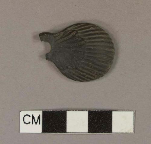 Molded black basalt stoneware object; scallop shell-shape with fragment of loop on top