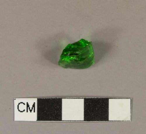 Green bottle glass fragment, embossed with an unknown bit of a letter