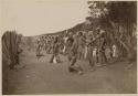 Male pilou-pilou dancers outside with spears