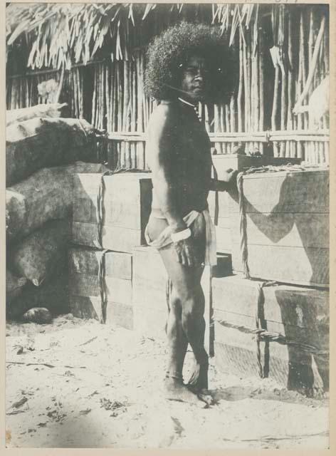 Man standing in front of wooden boxes and a structure