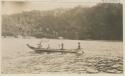 People in boats, shoreline in background