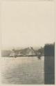 Bay, boat, thatched structures on shore