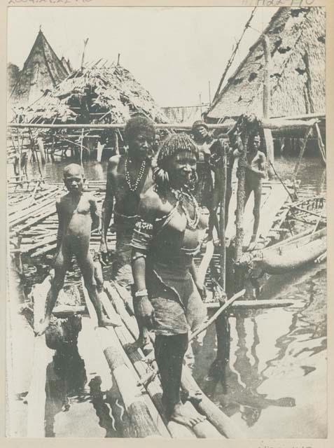 Group of people standing among piers and boats