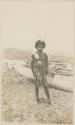 Man standing on the shore, boats in background