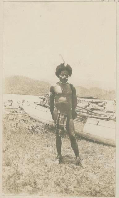 Man standing on the shore, boats in background